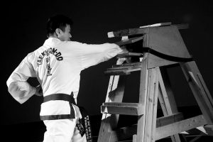 Photo of Tak smashing a plank of wood with his Taekwon-do skills